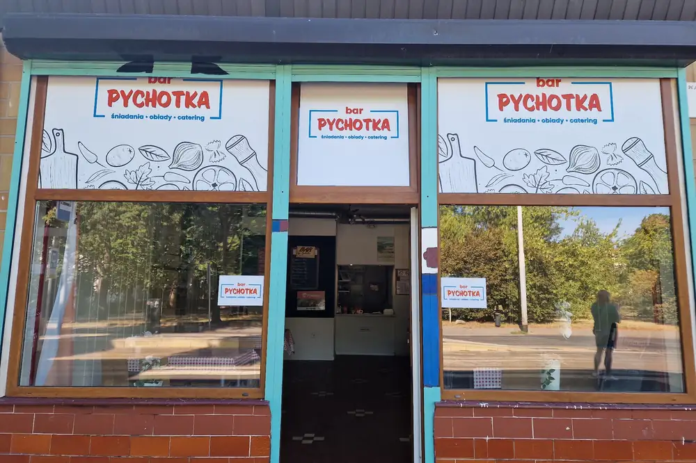 Wejście do baru Pychotka z szyldami „śniadania • obiady • catering”