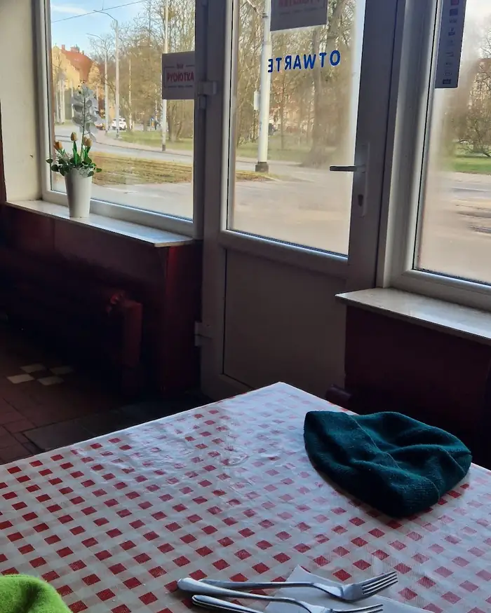Stolik z czerwonym obrusem w kratkę przy oknie
